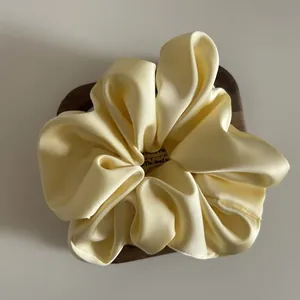 Elegant cream yellow oversized satin scrunchie with silky texture and soft folds