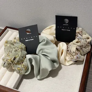 Lot de 3 chouchous en satin et motif floral au style vintage sur un plateau à bijoux