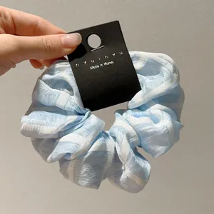 Λεπτομερής όψη του μεγάλου υφασμάτινου scrunchie με μπλε και λευκές ρίγες