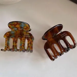 Dettaglio di fermagli per capelli in acetato tartarugato con design multi-dente