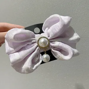 Detailaufnahme der fliederfarbenen Schleife mit Perle und Strassbesatz auf dem Haarclip