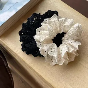 Close-up of elegant lace scrunchies in black and white with floral hollow patterns