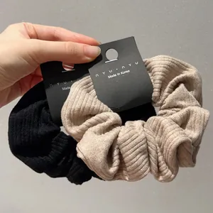 French style striped knit scrunchies in black and beige with soft ribbed fabric texture