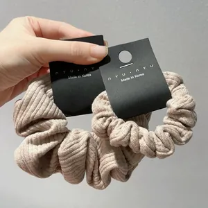 Detailed close-up of khaki ribbed knit scrunchies set with a clear vertical stripe texture
