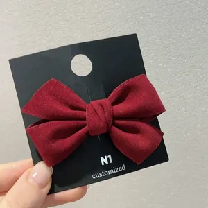 Gros plan d'une barrette noeud en velours bordeaux montrant la texture du tissu