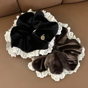 Detail of vintage velvet scrunchies with white lace edges and gold metal charms