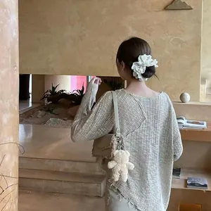 Detail of elegant white embroidered lace scrunchie with floral cutouts on a low ponytail