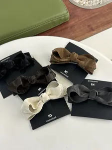 Detail showing five colors of pleated bow hair clips on black display cards