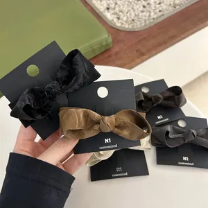 Chic faux leather bow hair clips in assorted colors on display card for women