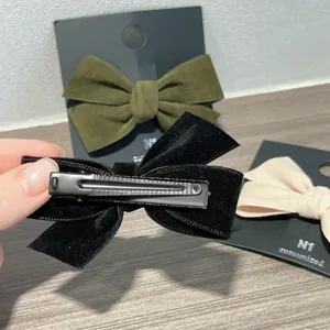 Barrette à nœud papillon en velours vintage avec pince crocodile sur carte noire
