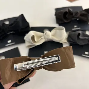 Detail of premium leather-textured bow hair clip with silver metal alligator clip