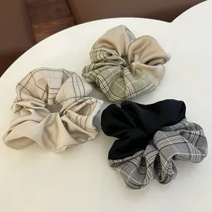 Detail von karierten und Satin-Scrunchies in Creme, Grün und Schwarz im Patchwork-Design
