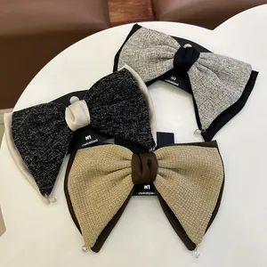 Détail de trois nœuds à cheveux en tweed et satin avec perles sur carte de support