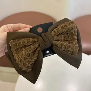 Bruine haarstrik met wafelstructuur stof stiksels op een merk kaartje