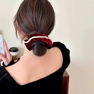 French vintage red velvet scrunchie with pearls styled on a high bun hairstyle