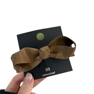 Elegant brown bow hair clip in Korean style with textured fabric and matte finish