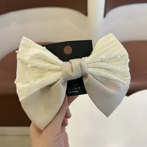 Λεπτομέρεια από το ιβουάρ κλιπ μαλλιών με φιόγκο από ανάγλυφο ύφασμα και σατέν