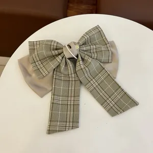 Detail einer Vintage-Schleifen-Haarklammer mit Karomuster, Satin und Perlenverzierung