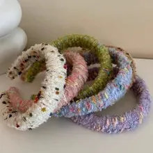 Close-up of fluffy thick tweed headbands in five pastel colors with colorful sequins