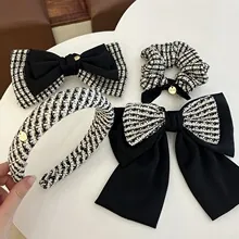 Detail of tweed hair accessory set featuring headband, scrunchie and bow clips in black and white