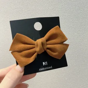 Barrette à cheveux avec nœud en velours daim marron caramel sur carte de support