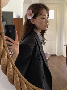 Mirror selfie showing a pink orchid flower hair claw clip on side-swept hair style
