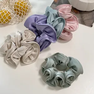 Macro detail of assorted Morandi satin silk oversized scrunchies in five elegant pastel colors