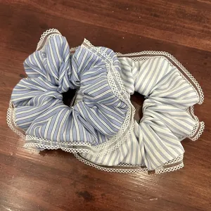 Blue and white striped hair scrunchies with white lace trim on wooden background