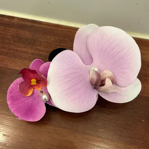 Detail of realistic orchid hair claw with purple gradient petals and center pearls