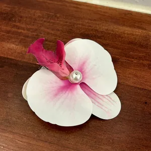 Detail of faux orchid hair claw with pink gradient petals and a pearl center