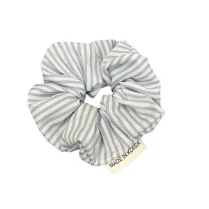 Chouchou à rayures bleues et blanches avec étiquette Made in Korea sur fond blanc