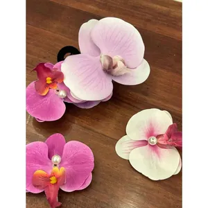 Elegant Phalaenopsis orchid hair clips with pearls on a rustic wood background