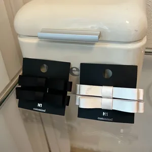 Detalle de pinzas para el cabello con lazo de satén negro y plateado en cartón