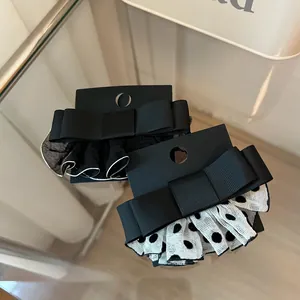 Detailansicht eleganter Schleifen-Haarspangen aus Ripsband mit gepunktetem Tüllnetz