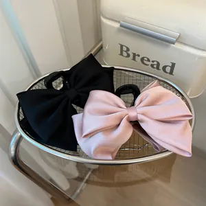 Elegant large satin bow hair claw clips in black and pink for women's hairstyling