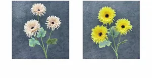 Detail view of artificial African daisies in light brown and yellow with green leaves