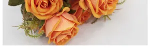Detalle macro de pétalos de rosa naranja de seda y hojas verdes en un ramo de novia