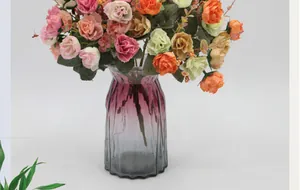 Detailed view of artificial diamond roses in a ribbed gradient glass vase for home decor