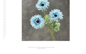 Dettaglio macro di gerbere blu artificiali con tre teste in fiore e stelo verde per decor