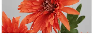 Macro dei petali di gerbera in seta arancione e dettagli della trama della foglia