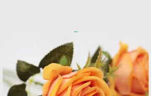 Makroaufnahme orangefarbener Samt-Kunstrosen mit realistischen Blüten und gezackten Blättern