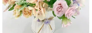 Close-up of artificial rose bouquet with pink and champagne flowers in a woven vase