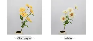 Dettaglio di crisantemi artificiali color champagne e bianco in un vaso di ceramica