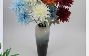 Detailed view of colorful faux chrysanthemums in a gradient ceramic vase