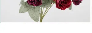 Close-up of artificial autumn diamond rose bouquet with realistic dark red silk petals