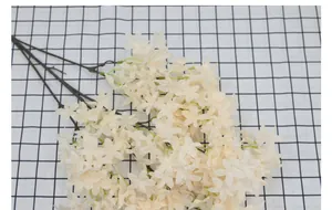 Macro shot of white silk cherry blossom branch with detailed petals and brown stem