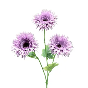 Gerbere viola artificiali con tre capolini e foglie verdi su uno sfondo bianco puro