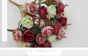 Close-up of vintage-style artificial silk roses in red, pink, and cream with green leaves
