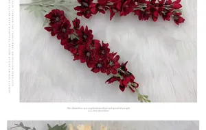 Close-up of deep red faux delphinium silk flowers with white stamens on white plush rug