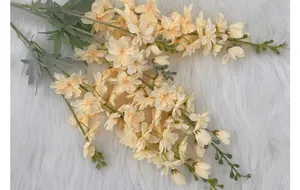 Detail of silk delphinium petals in champagne cream on soft white faux fur background